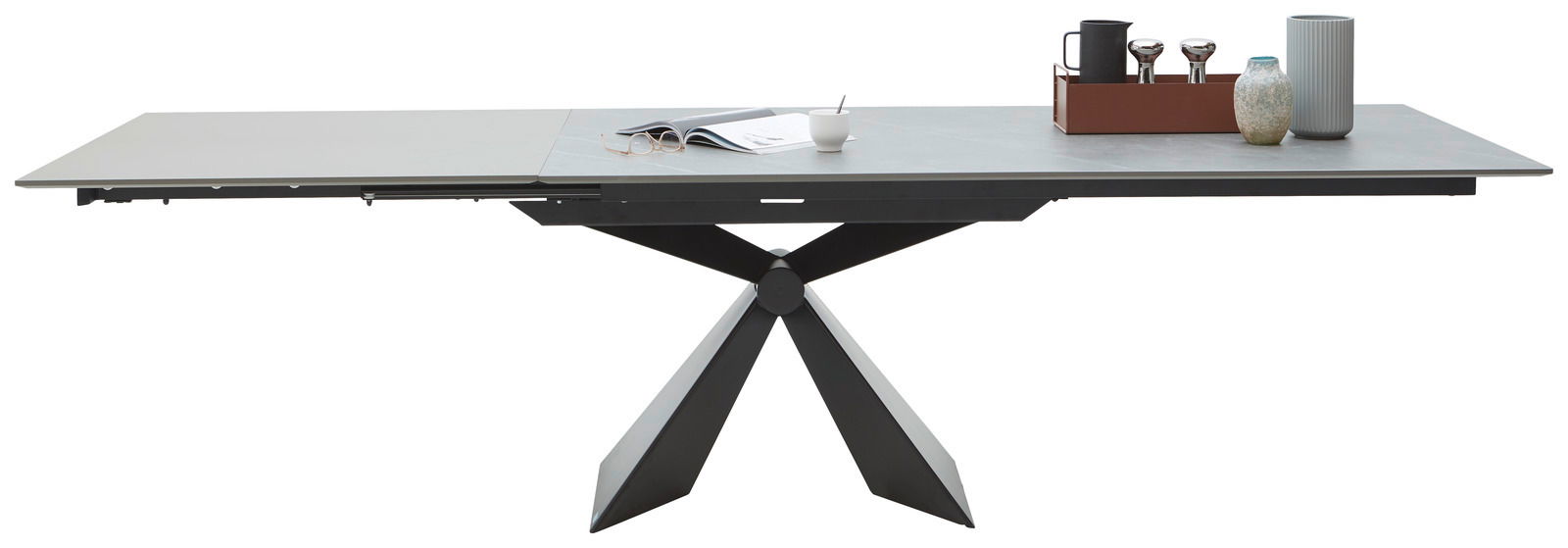 Moderner Esstisch mit ausziehbarer Tischplatte und geometrischem Metallgestell, seitliche Perspektive.