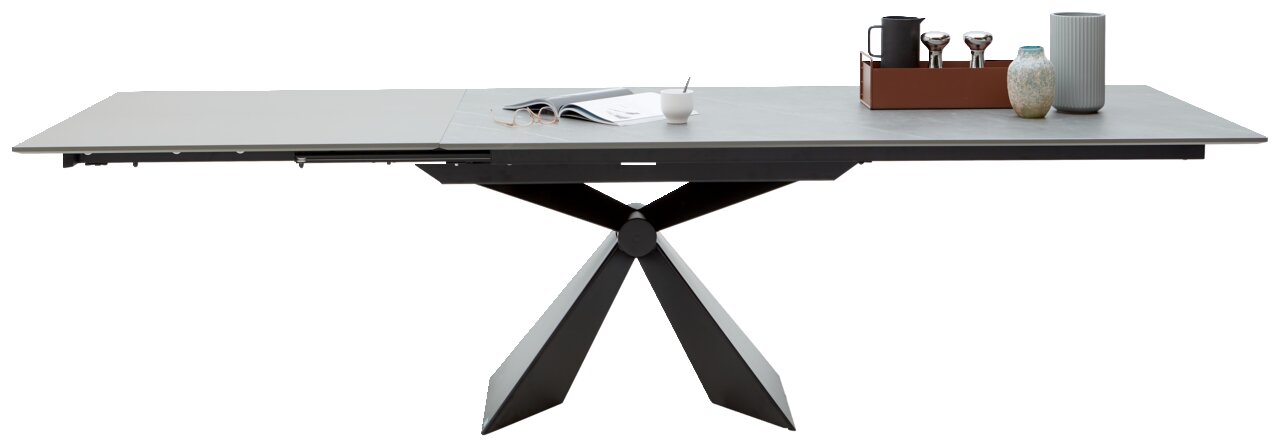 Moderner Esstisch mit ausziehbarer Tischplatte und geometrischem Metallgestell, seitliche Perspektive.