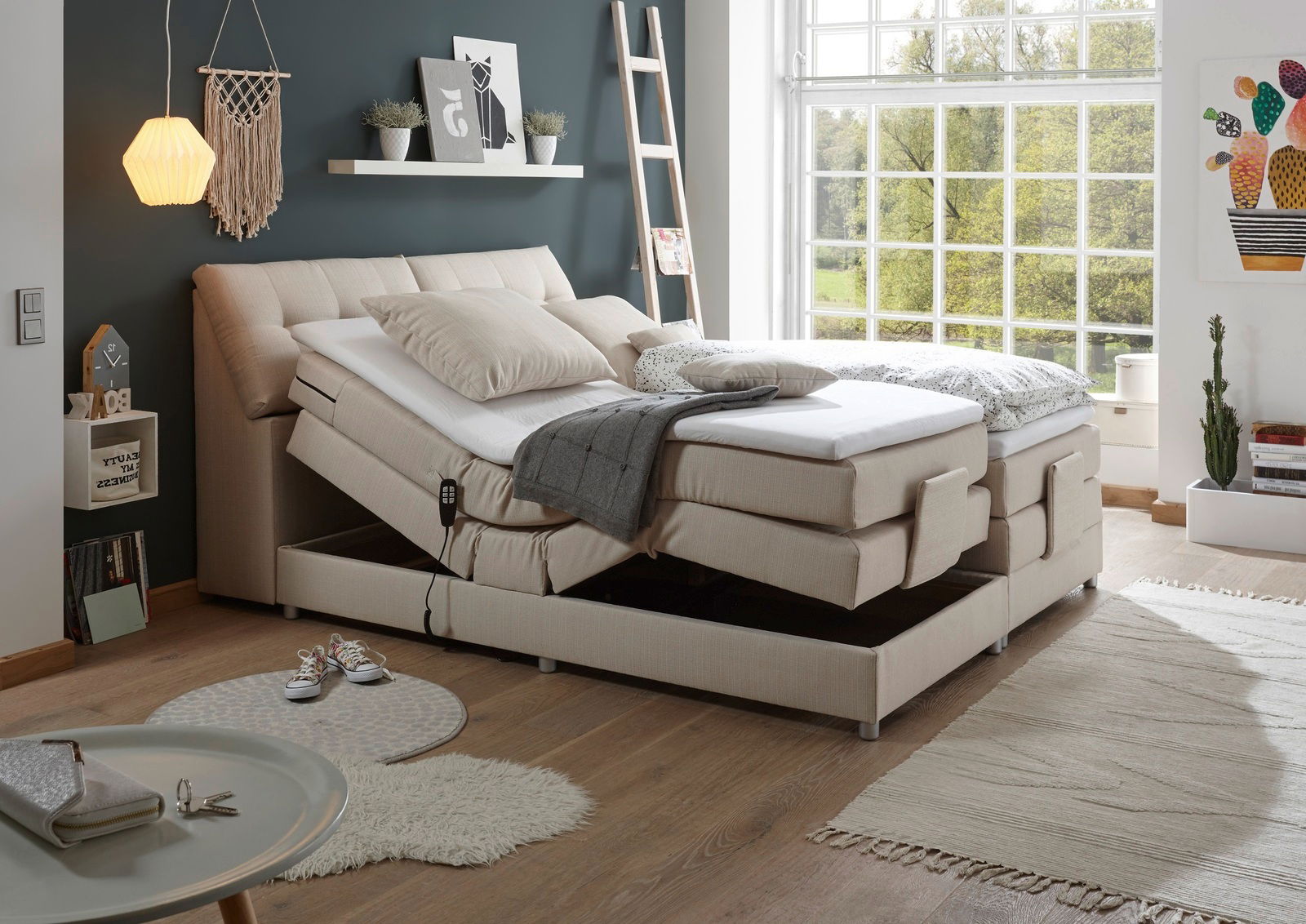 Modernes Boxspringbett in einem hellen Schlafzimmer mit verstellbaren Matratzen und gemütlicher Dekoration, seitliche Perspektive.