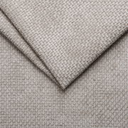 Nahaufnahme eines beigen, strukturierten Stoffes mit gewebtem Muster, verwendet für ein Polsterbett.