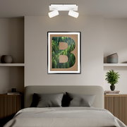 Zweiflammiger LED-Spot in modernem Design, an der Decke über einem stilvoll eingerichteten Schlafzimmer montiert, mit Blick von vorne.