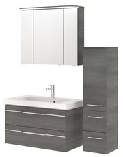 Badezimmermöbel-Set in grauer Holzoptik, bestehend aus einem Spiegelschrank, einem Waschtisch mit zwei Schubladen und einem hohen Schrank, frontal betrachtet.