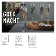 Ein Set von eleganten Champagnergläsern mit goldenen Verzierungen, präsentiert auf einem Tisch mit Blumen im Hintergrund. Perspektive: seitlich.