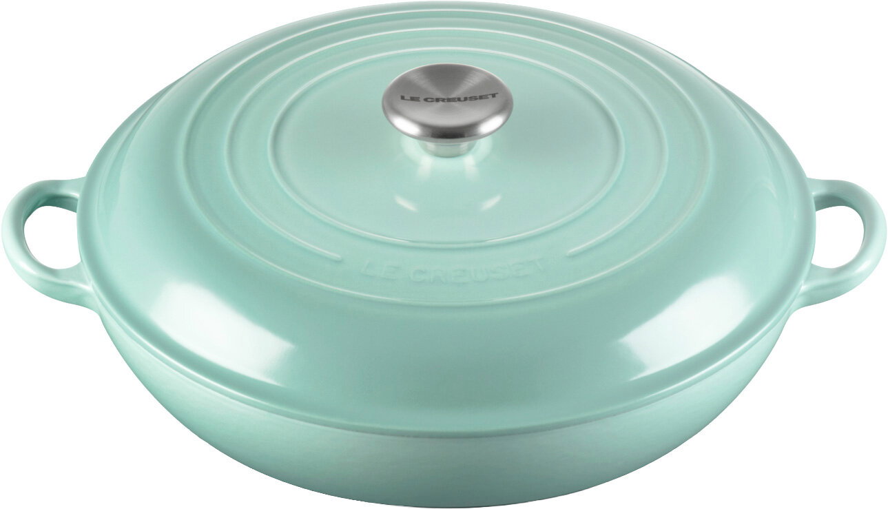 Türkisfarbener Le Creuset Schmortopf/Bräter mit Deckel und zwei Griffen, Studioaufnahme in leicht schräger Draufsicht von vorne