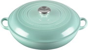 Türkisfarbener Le Creuset Schmortopf/Bräter mit Deckel und zwei Griffen, Studioaufnahme in leicht schräger Draufsicht von vorne