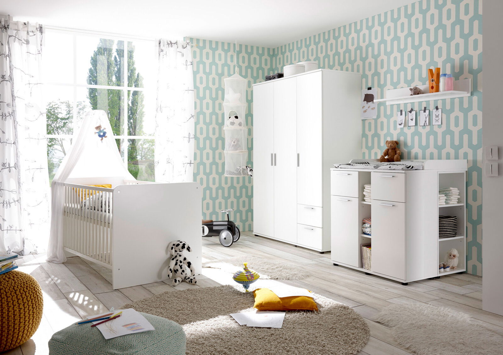 Helles Kinderzimmer mit Babybett, Kleiderschrank und Wickelkommode in moderner Einrichtung, seitliche Perspektive