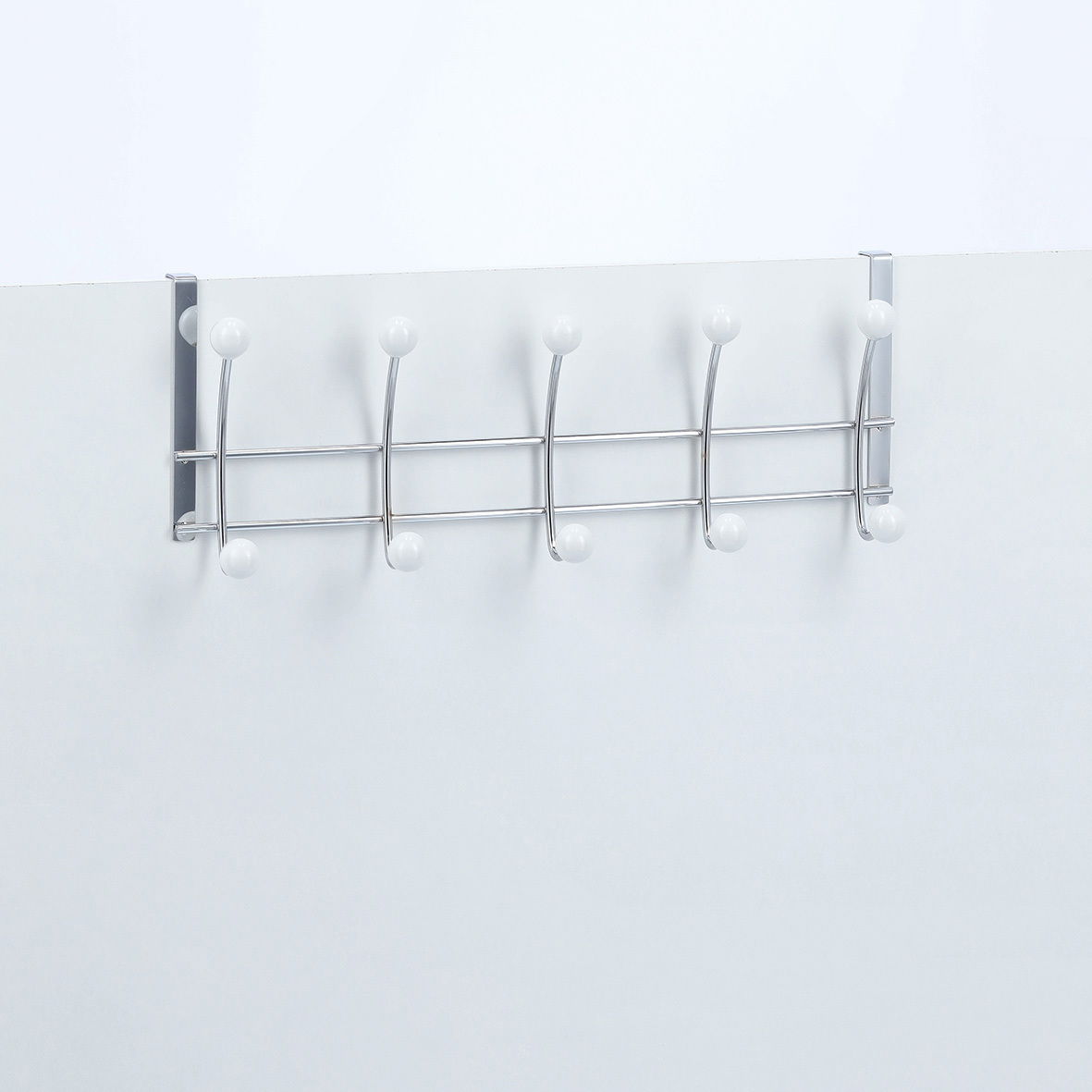 Türhängeleiste mit fünf Haken, aus Metall mit weißen Kugelenden, frontal an einer Tür montiert.