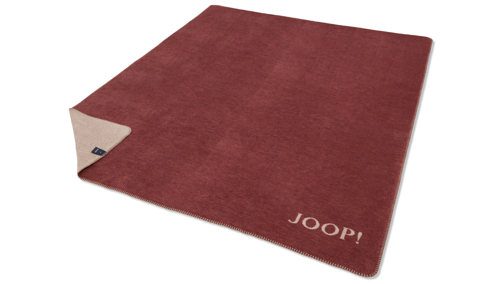 Rote JOOP! Decke mit beiger Rückseite, ausgebreitet auf einer Fläche, mit sichtbarem Markenlogo in der Ecke.