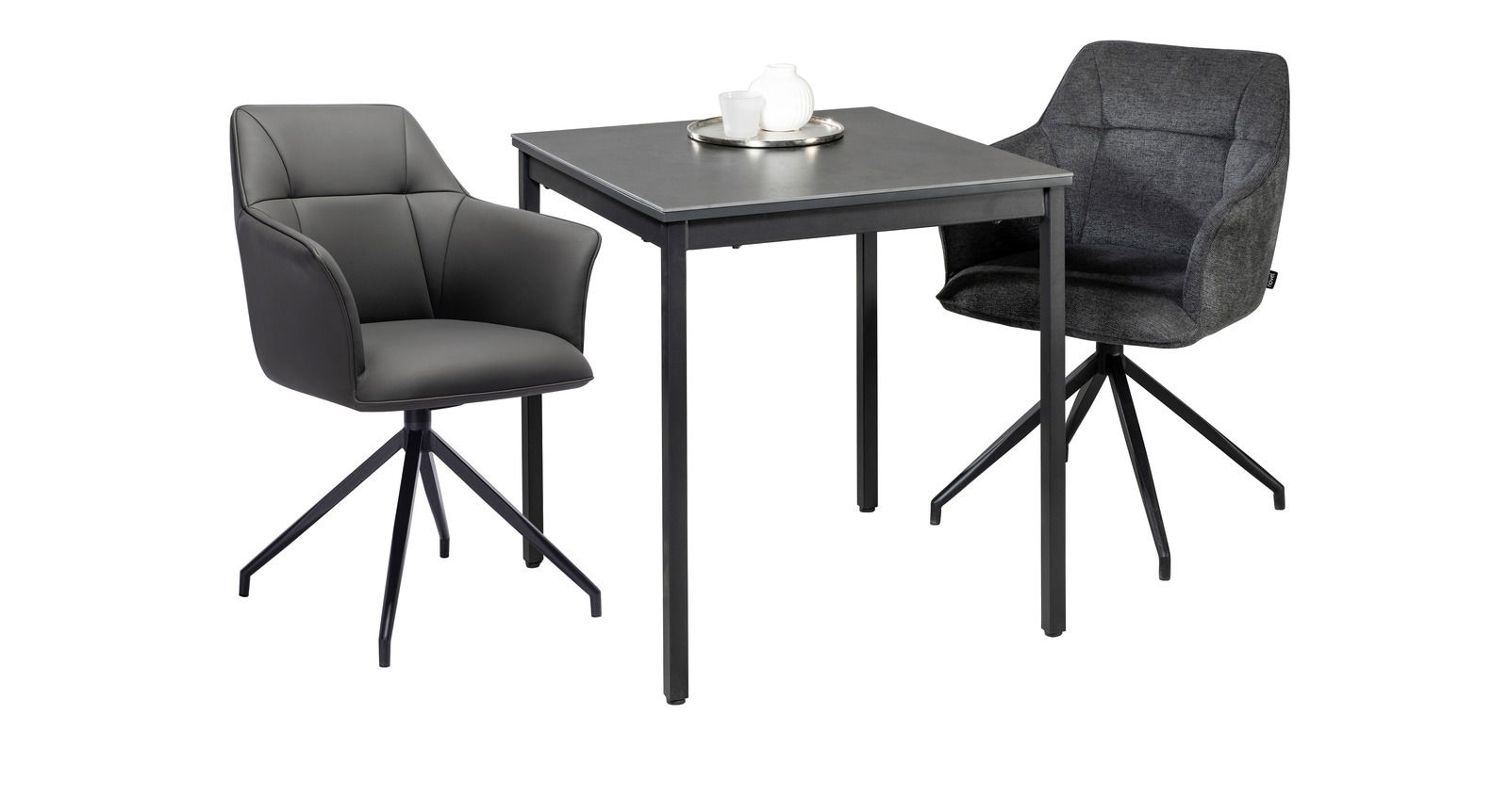 Moderner Esstisch mit zwei Armlehnstühlen, einer in grauem Leder und der andere in dunklem Stoff, aus seitlicher Perspektive.