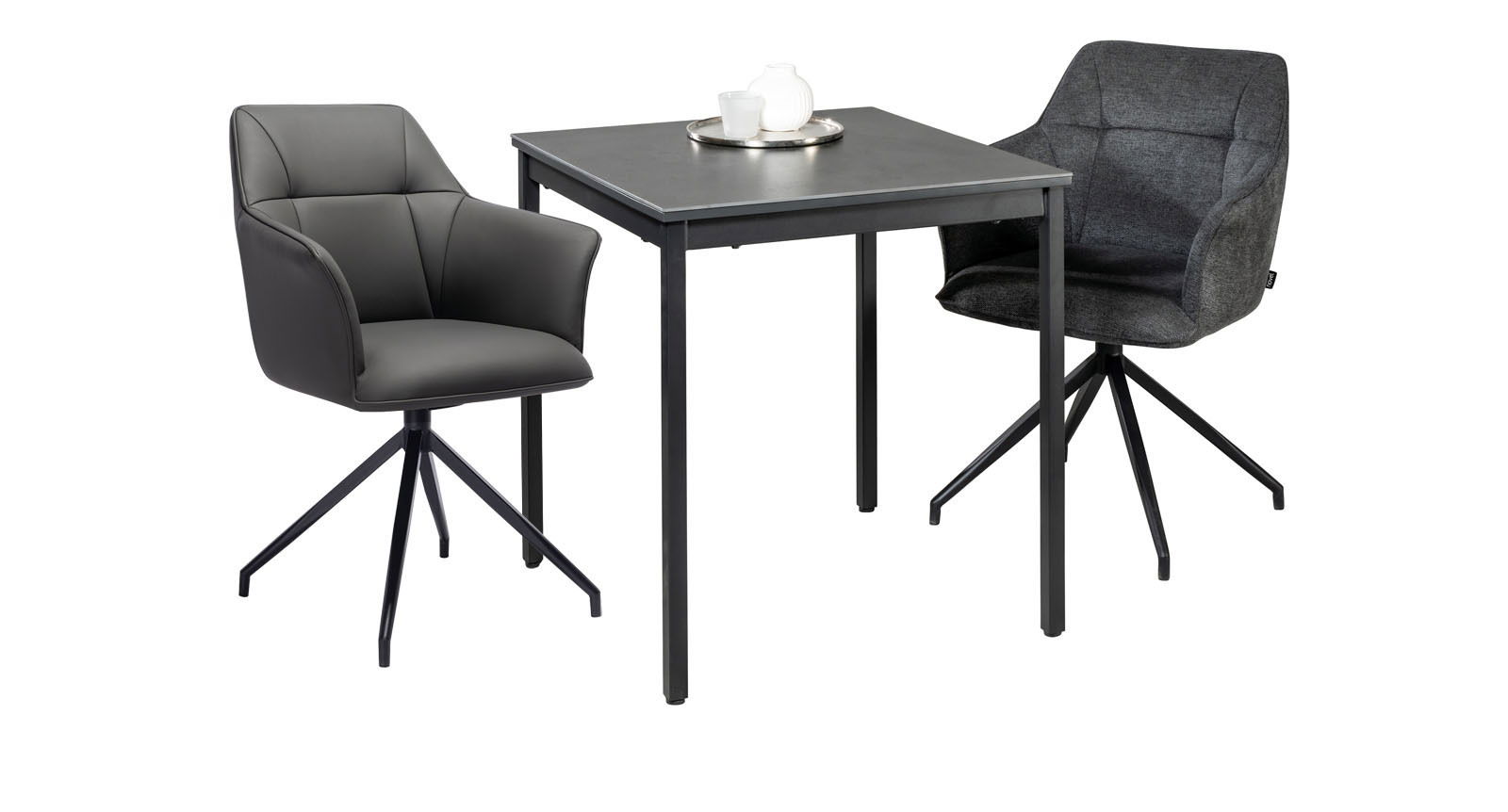 Moderner Esstisch mit zwei Armlehnstühlen, einer in grauem Leder und der andere in dunklem Stoff, aus seitlicher Perspektive.