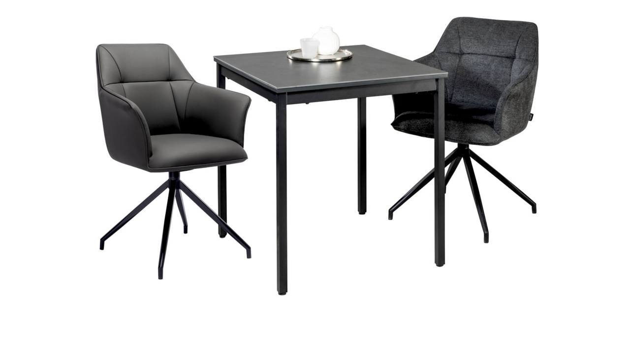 Moderner Esstisch mit zwei Armlehnstühlen, einer in grauem Leder und der andere in dunklem Stoff, aus seitlicher Perspektive.