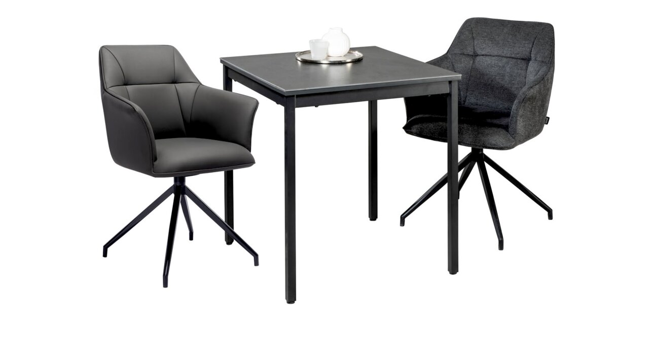 Moderner Esstisch mit zwei Armlehnstühlen, einer in grauem Leder und der andere in dunklem Stoff, aus seitlicher Perspektive.