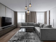 Moderne Hängeleuchte mit drei Glaskugeln in einem stilvollen Wohnzimmer, seitliche Perspektive.