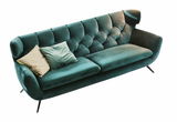 Grünes, zweisitziges Sofa mit zwei Kissen, schräg von oben fotografiert.