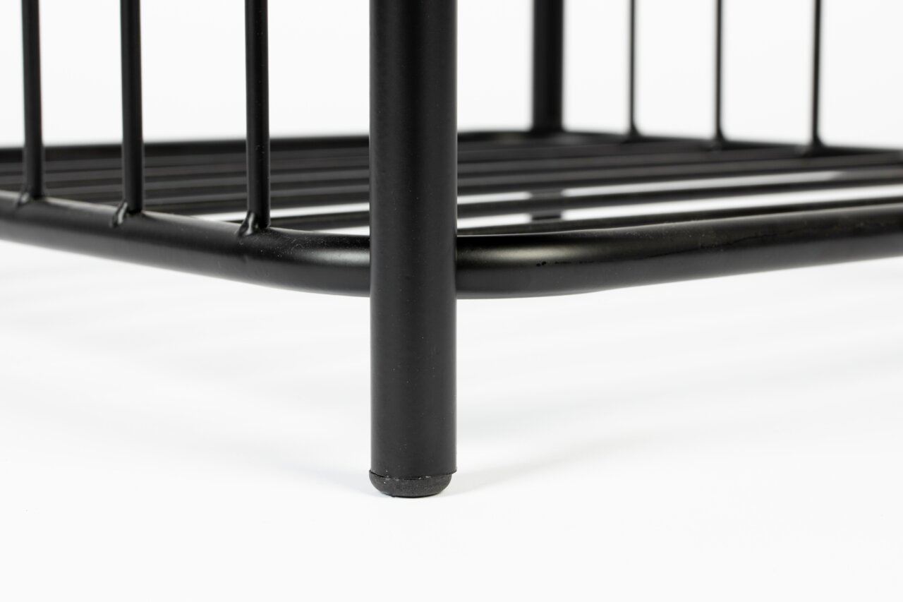 Close-up van een zwart metalen frame van een kruk, vanuit een laag standpunt gefotografeerd.