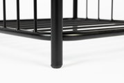 Close-up van een zwart metalen frame van een kruk, vanuit een laag standpunt gefotografeerd.