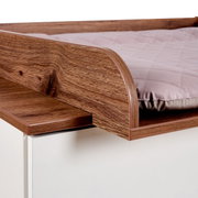 Close-up van een commode met houtlook en gestoffeerd blad, gezien vanaf de zijkant