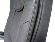 Nahaufnahme eines grauen Chefsessels mit sichtbaren Nähten und Textur, seitliche Perspektive