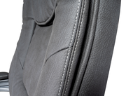 Nahaufnahme eines grauen Chefsessels mit sichtbaren Nähten und Textur, seitliche Perspektive