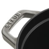 Nahaufnahme des Griffs eines ovalen Bräters von Staub, Perspektive von oben