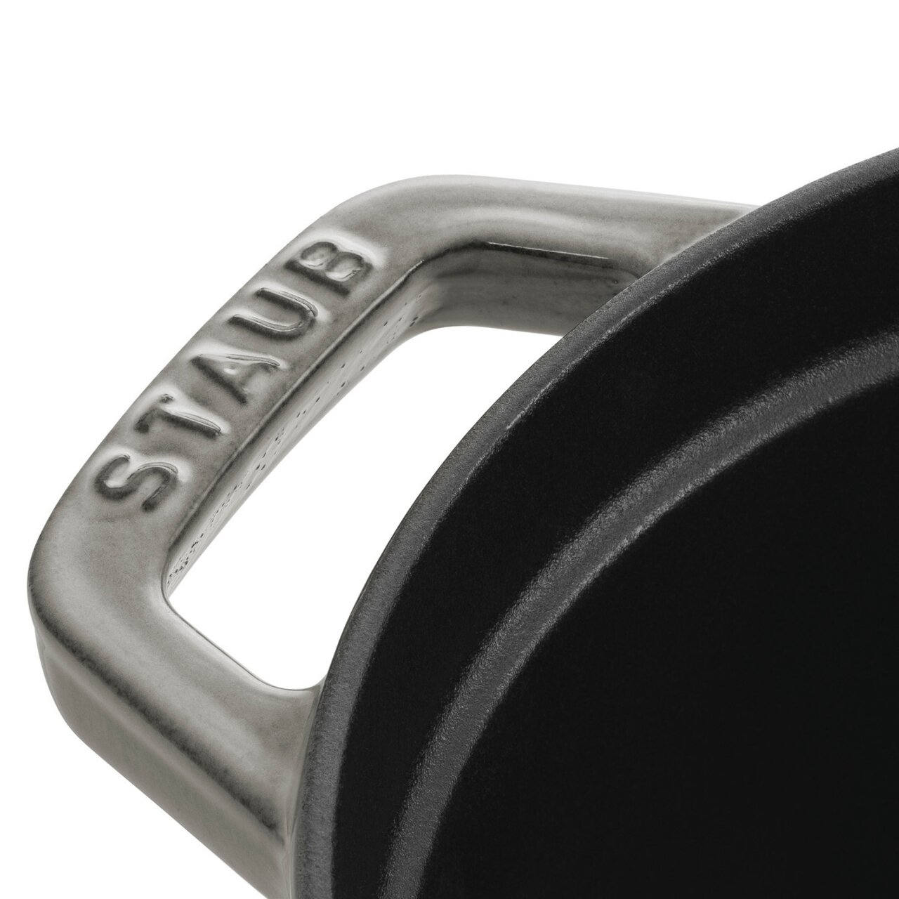 Close-up van het handvat van een ovale braadpan van Staub, gezien van bovenaf