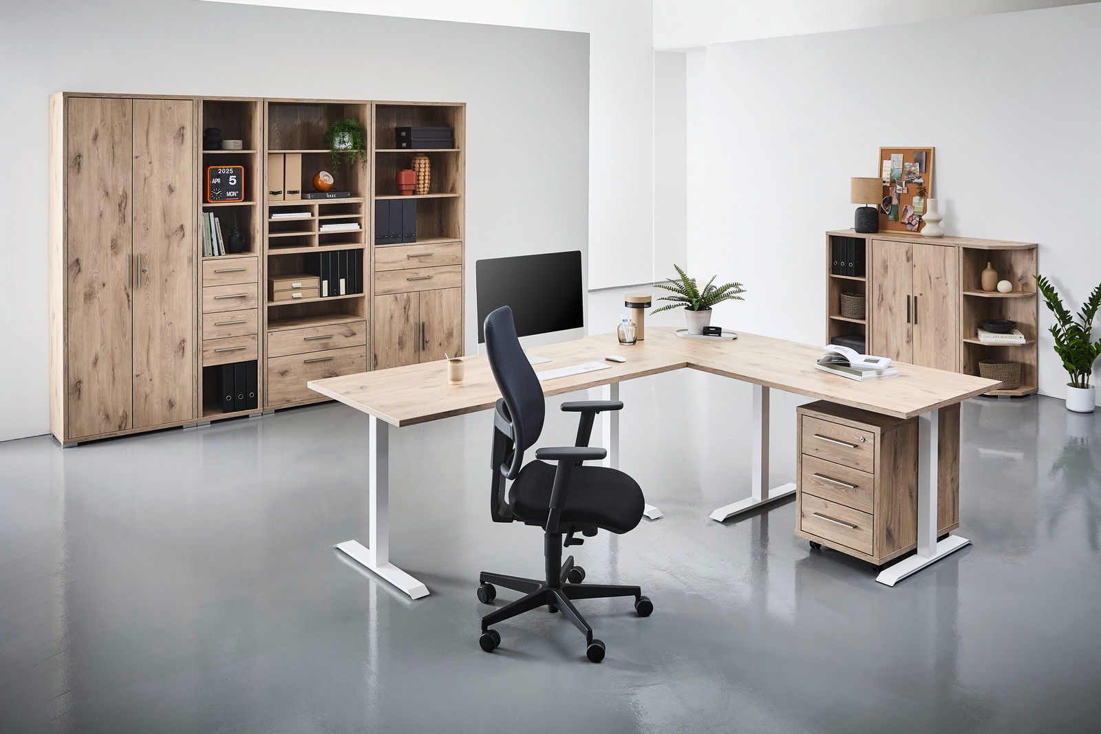 Moderne Büromöbel in Holzoptik mit L-förmigem Schreibtisch, ergonomischem Bürostuhl und Regalsystemen, seitliche Perspektive