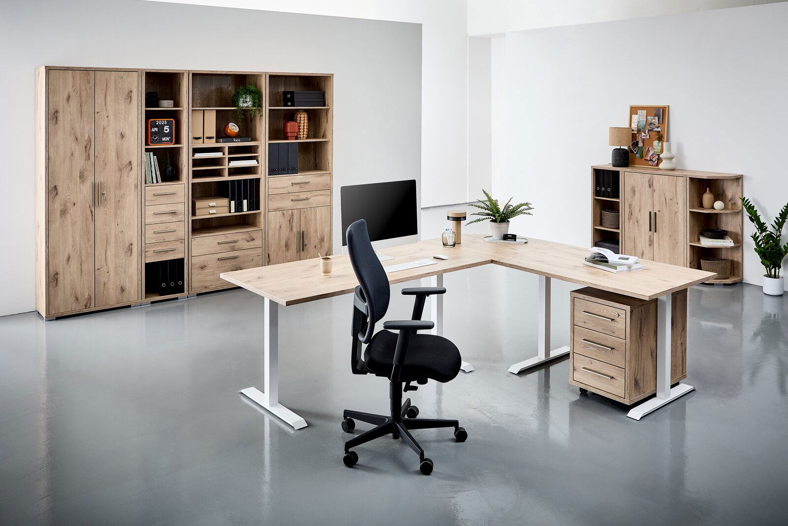 Moderne Büromöbel in Holzoptik mit L-förmigem Schreibtisch, ergonomischem Bürostuhl und Regalsystemen, seitliche Perspektive