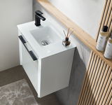 Modernes weißes Waschbecken mit schwarzem Wasserhahn, von oben fotografiert, in einem stilvollen Gästebad mit Holz- und Betonelementen.