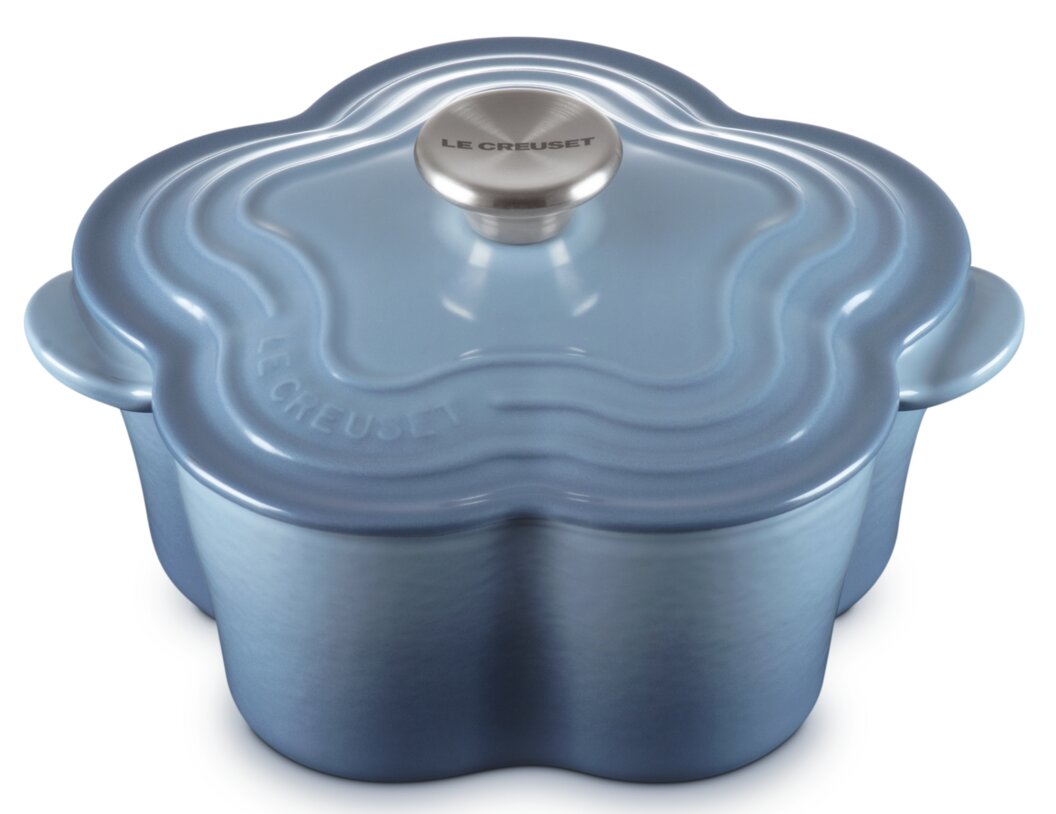 Lichtblauwe gietijzeren braadpan van Le Creuset in bloemvorm, met deksel en roestvrijstalen knop, schuin van bovenaf gezien in vooraanzicht, vrijstaand op een witte achtergrond