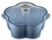 Hellblauer Le Creuset Gusseisen-Bräter in Blumenform mit Deckel und Edelstahlknauf, schräg von oben in Frontansicht freigestellt auf weißem Hintergrund