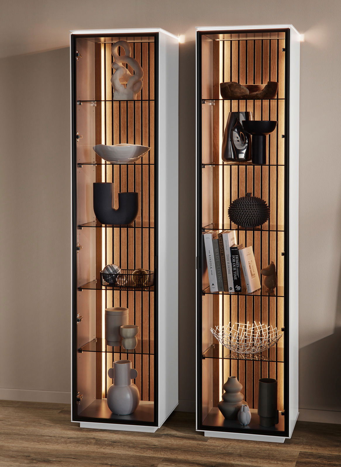 Zwei moderne Vitrinen mit Glasregalen und dekorativen Objekten, frontal betrachtet, mit integrierter Beleuchtung.