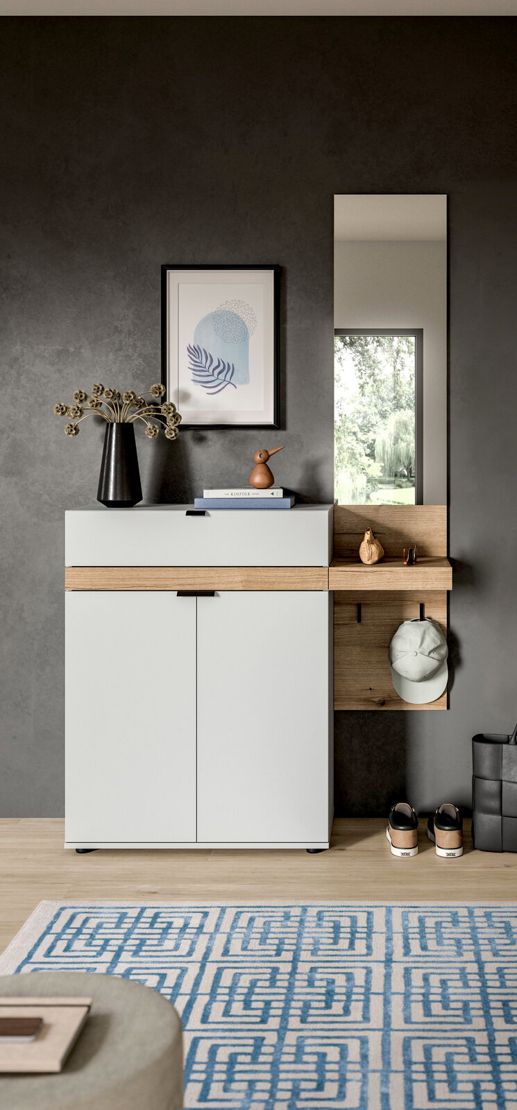 Modernes Flurmöbel/Schuhschrank in Weiß mit Holz-Akzenten, seitlichem Regal und Spiegel vor grauer Wand, frontal aus leicht erhöhter Perspektive fotografiert