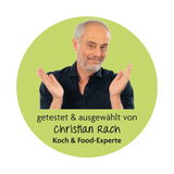 Mann in schwarzem Hemd vor grünem Hintergrund, getestet und ausgewählt von Christian Rach, Koch & Food-Experte, frontal