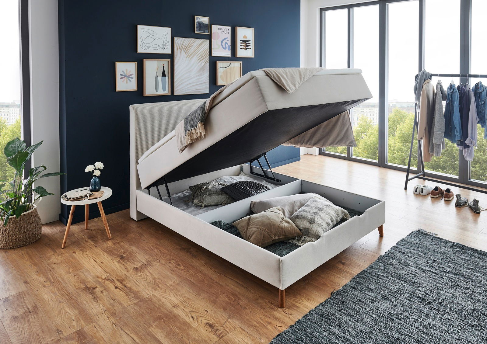 Boxspringbett mit hochgeklappter Matratze und Stauraum, seitliche Perspektive in modernem Schlafzimmer