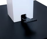 Nahaufnahme eines Couchtischs mit schwarzer Oberfläche und weißem quadratischen Element, seitliche Perspektive.