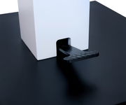 Nahaufnahme eines Couchtischs mit schwarzer Oberfläche und weißem quadratischen Element, seitliche Perspektive.