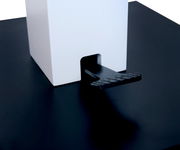 Nahaufnahme eines Couchtischs mit schwarzer Oberfläche und weißem quadratischen Element, seitliche Perspektive.