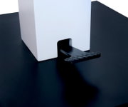 Nahaufnahme eines Couchtischs mit schwarzer Oberfläche und weißem quadratischen Element, seitliche Perspektive.