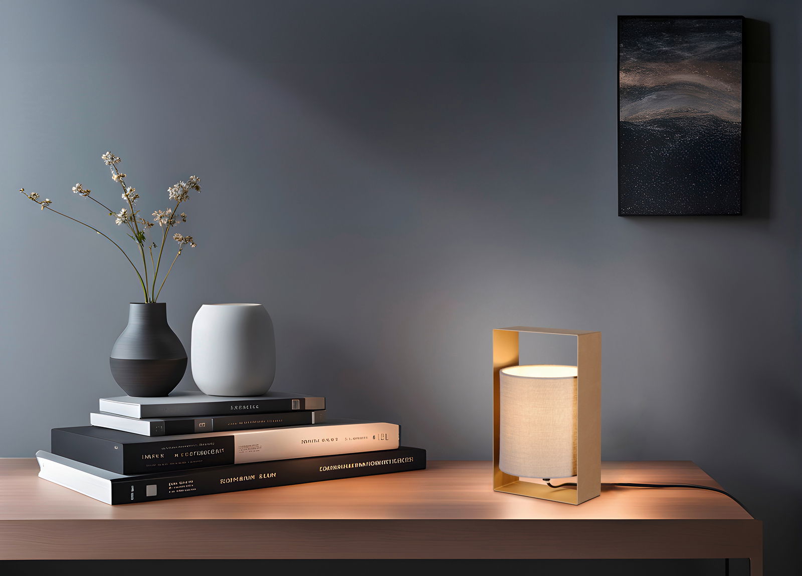 Moderne Tischleuchte mit rechteckigem, goldfarbenem Rahmen und zylindrischem, weißem Lampenschirm auf einem Holztisch, seitliche Perspektive.