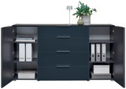 Modernes Sideboard in dunklem Blau mit offenen Türen, zeigt Regale mit Ordnern und Schubladen, dekoriert mit einer Pflanze und Lampe auf der Oberseite, frontale Perspektive.