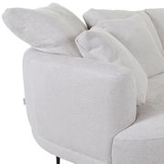 Nahaufnahme einer hellgrauen Rundecke mit Ottomane links, seitliche Perspektive.