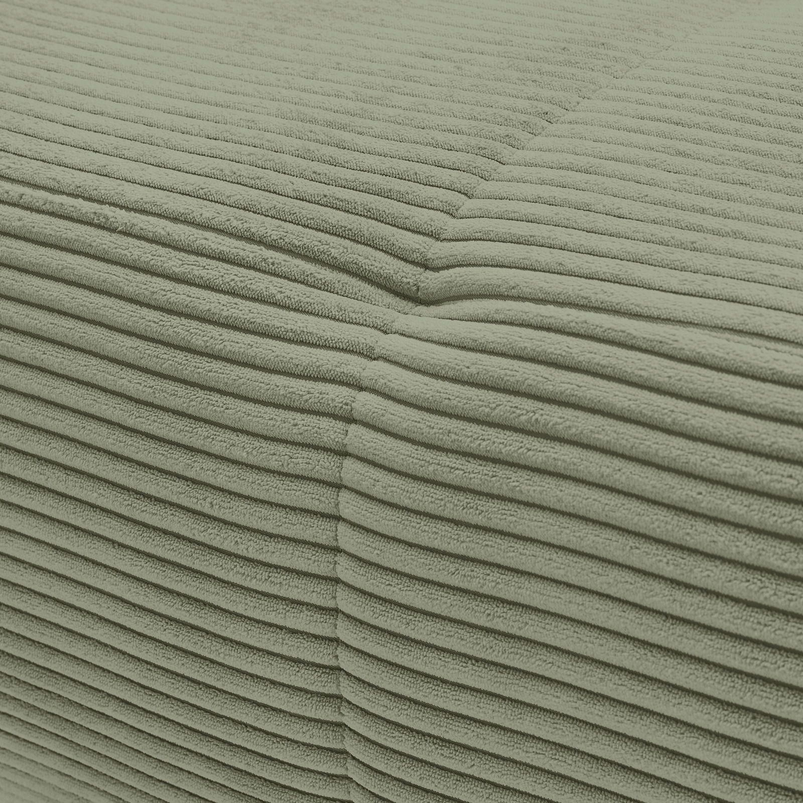Nahaufnahme einer grünen, gerippten Stoffoberfläche eines Sofas aus der Perspektive der Ecke.
