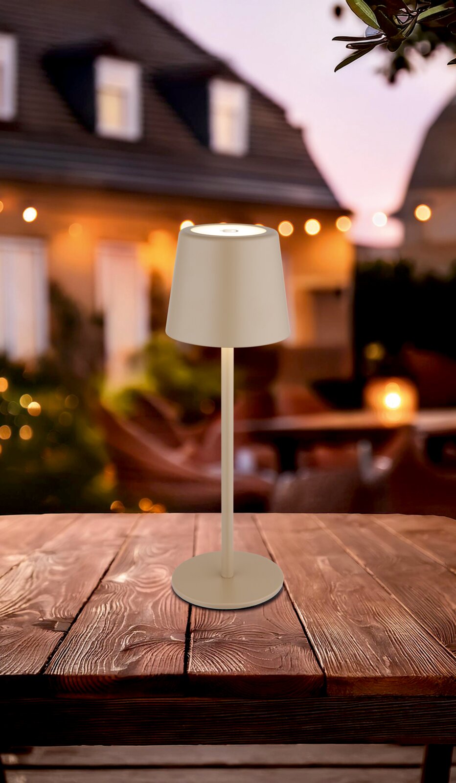 Moderne Tischleuchte in Beige auf einem Holztisch, fotografiert aus der Seitenperspektive mit einem unscharfen, stimmungsvollen Hintergrund.