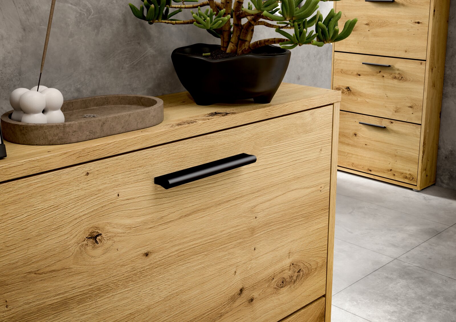 Nahaufnahme eines modernen Schuhkippers aus hellem Holz mit schwarzem Griff, dekoriert mit einer Pflanze und Accessoires, seitliche Perspektive.