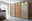 Moderner dreitüriger Schwebetürenschrank aus Holz und Glas mit integrierter Beleuchtung, seitliche Perspektive