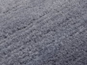 Nahaufnahme eines grauen Wollteppichs mit weicher, flauschiger Textur.