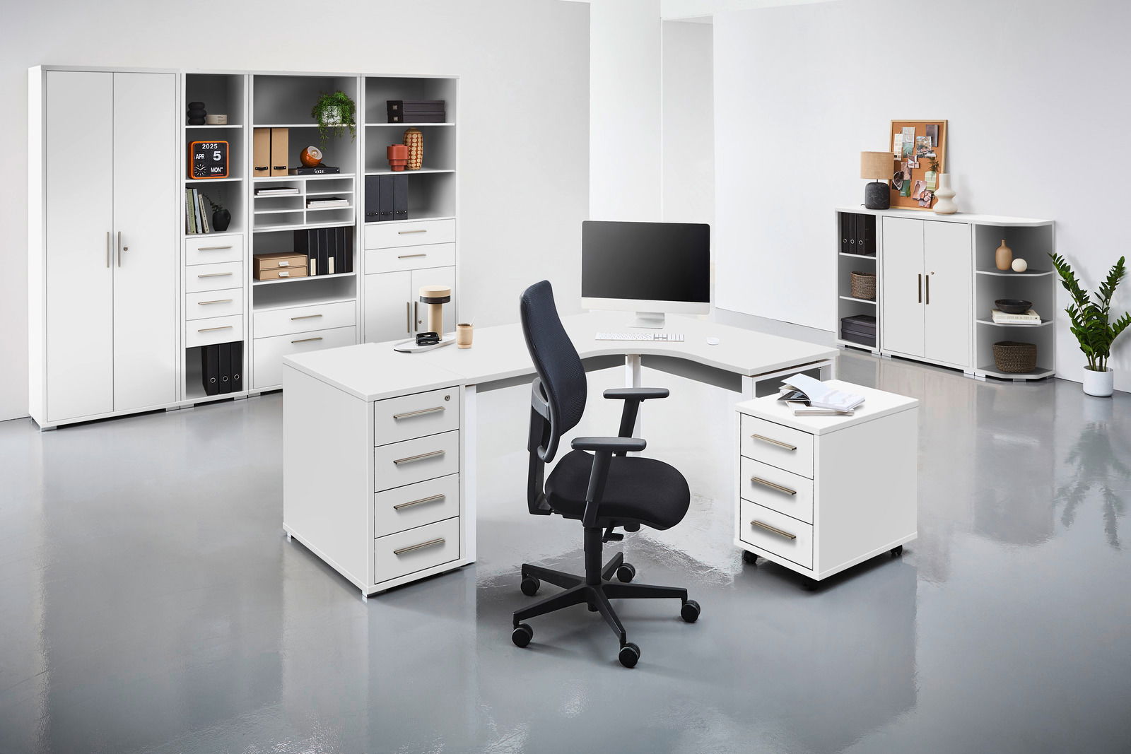 Moderne Büroumgebung mit weißem Eckschreibtisch, Rollcontainer und Bürostuhl, frontal betrachtet.