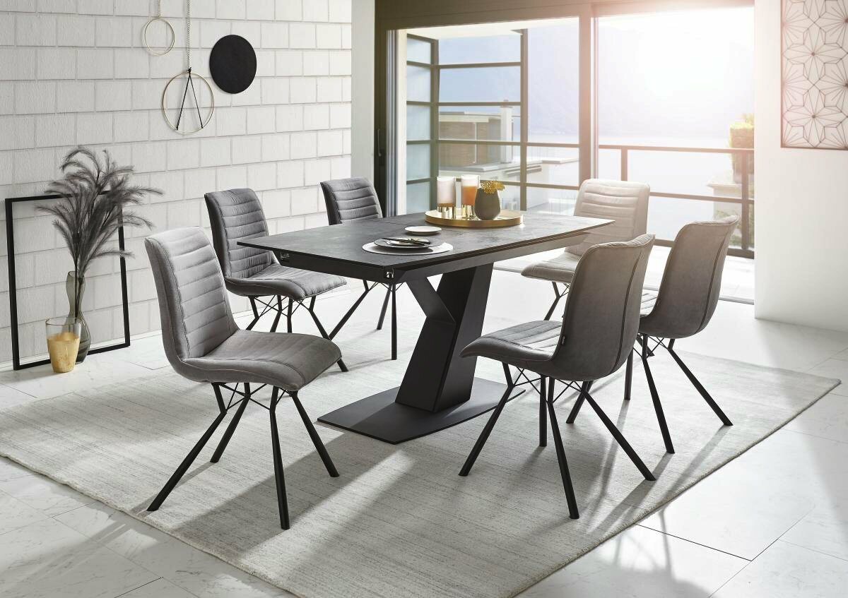 Novel Esstisch VANCOUVER Moderner Esstisch mit sechs grauen Stühlen in einem hellen Raum, seitliche Perspektive.