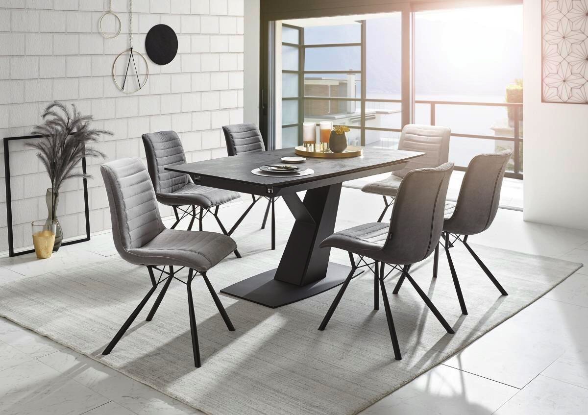 Moderner Esstisch mit sechs grauen Stühlen in einem hellen Raum, seitliche Perspektive.