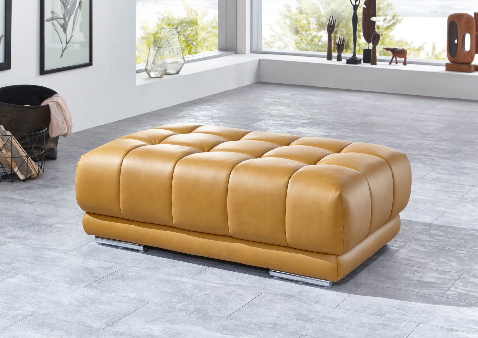 Beldomo Speed XXL-Hocker SPLIFF L XXL-Hocker in hellbraunem Leder, seitliche Perspektive, in modernem Wohnzimmer mit großen Fenstern.